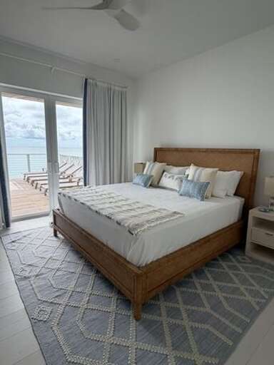 First master bedroom with king bed, en suite bath, and ocean view.