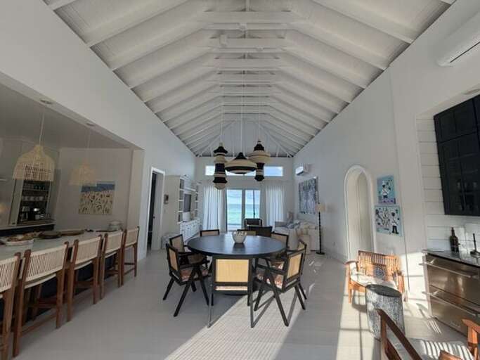 Ocean-view great room with a cathedral ceiling.  Kitchen is at left and bar at right.