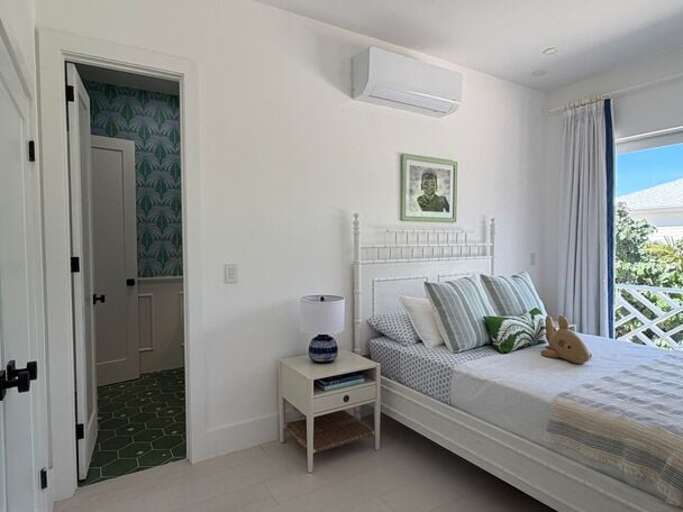 Third bedroom with queen bed, garden view, and en-suite full bath.