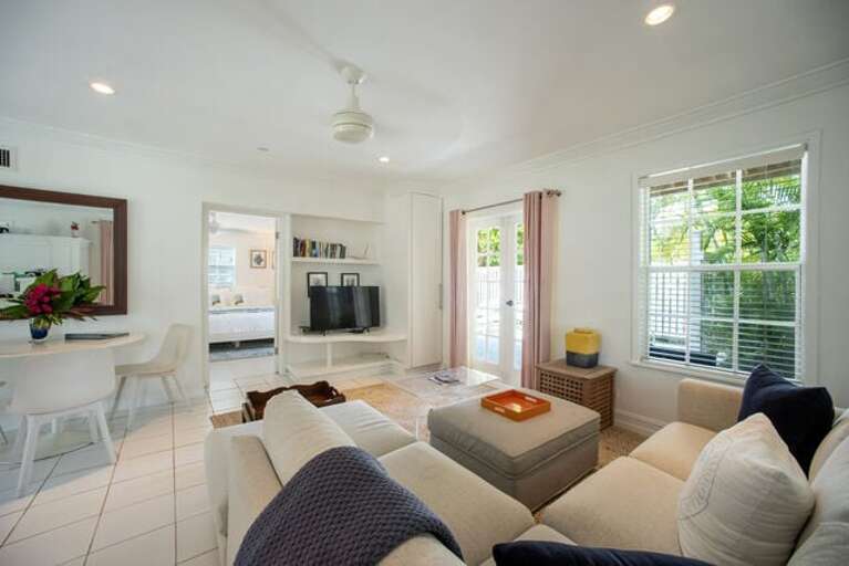 Peach house Downstairs has an open-plan living and dining area with French doors to a large patio.