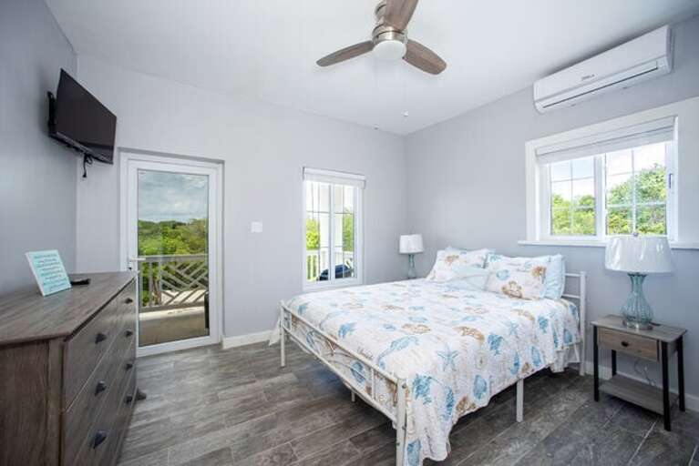The second bedroom features a queen bed, smart TV, and balcony access.  This bedroom shares a full bath with the third bedroom.