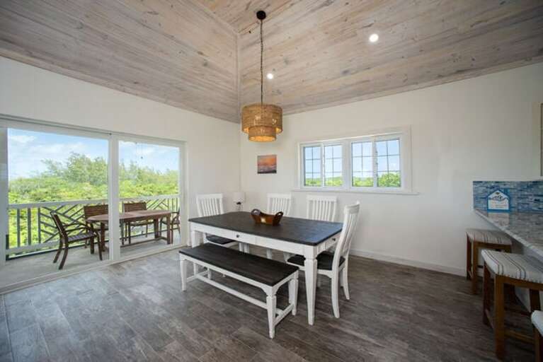 The dining area comfortably seats six and is ideal for gathering over meals, board games, or planning the next beach day.