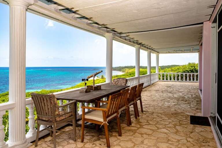 Atlantic-side (east) veranda has a large dining table and a separate seating area with a small table and a total of 8 chairs.
