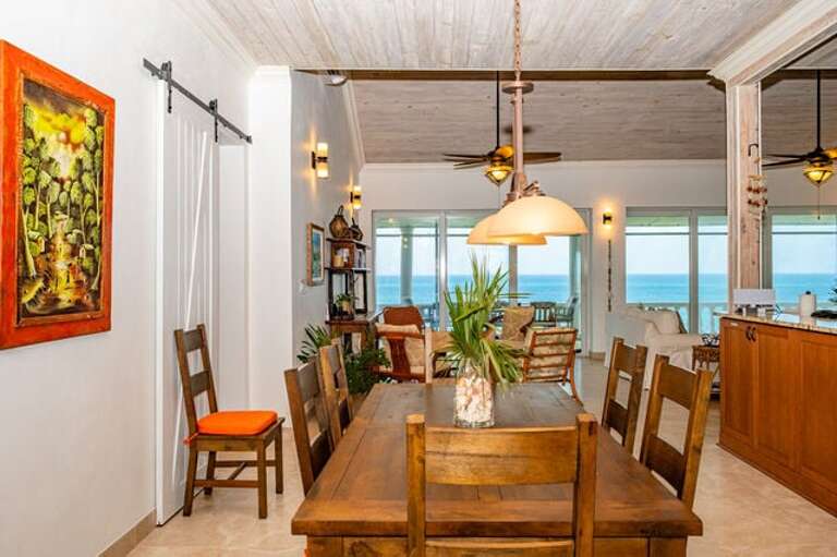 The dining area, which also enjoys ocean views, has a large table with 8 chairs.