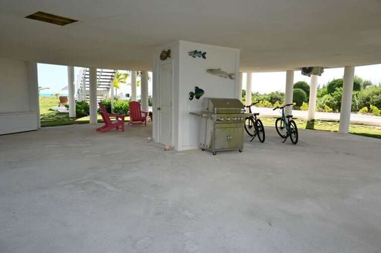 The covered patio beneath the house features a marine-grade Broilmaster grill built for the coastal elements.