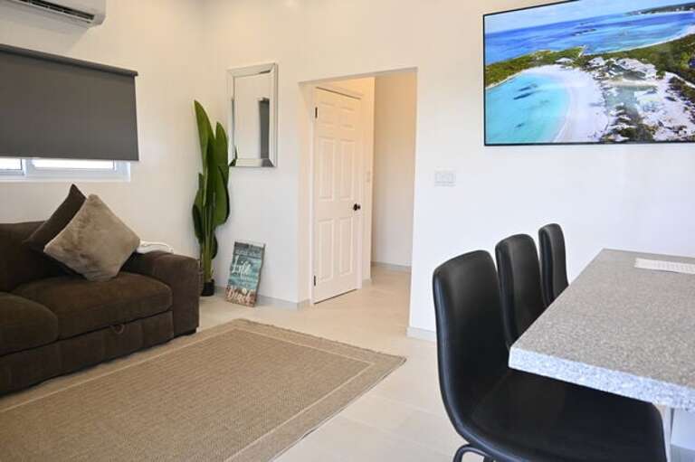 Great room featuring a spacious sectional and a wall-mounted 75-inch flat-screen TV.