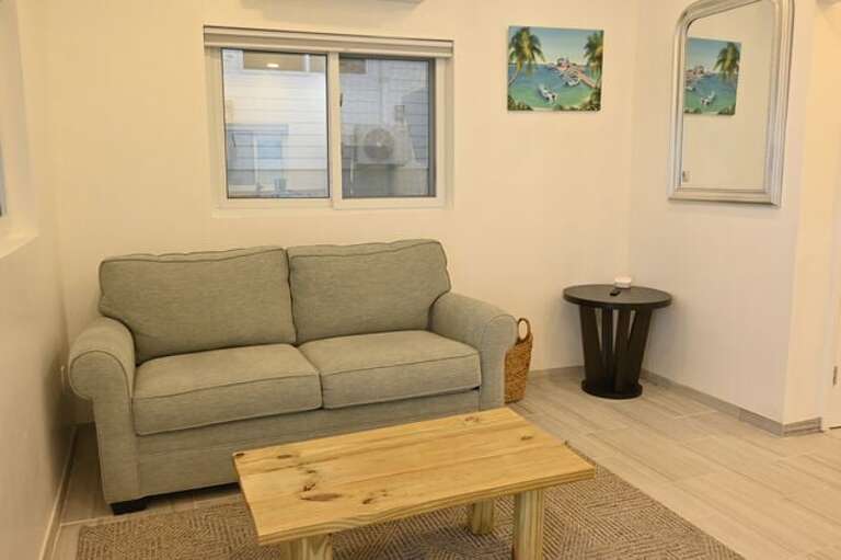 The great room features a sofa and a wall-mounted 75-inch flat-screen TV.