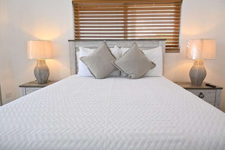 Each bedroom has a queen bed, a 65-inch wall-mounted flat-screen TV.