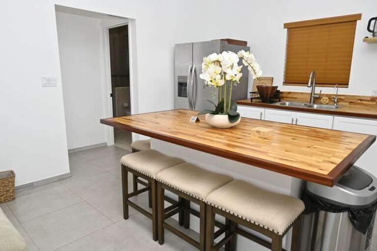 Sapphire Cottage features a modern island kitchen equipped with a French door refrigerator, glass-topped range and oven, and a microwave.