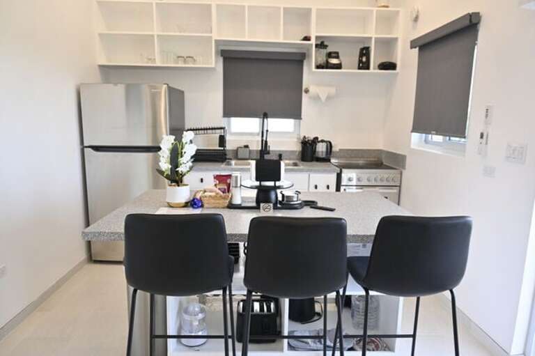 Crystal Cottage has a modern island kitchen equipped with a refrigerator, glass-topped range and oven, and a microwave.