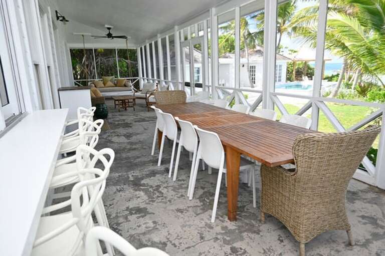 Main house screened porch with an ocean view.  This dining table seats 10, plus 6 at the counter.