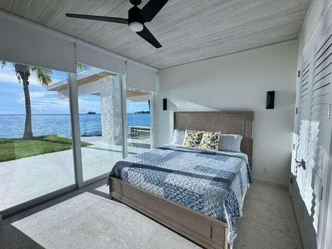 Guest cottage master bedroom with a wall of glass overlooking the Caribbean.