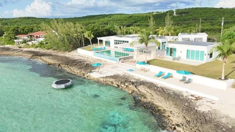 Sunset Dreams consists of a 4-bedroom main house (at left) and a 2-bedroom guest cottage, both with sweeping Caribbean views.
