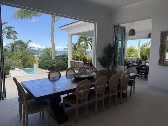 Dining area with the glass wall retracted to welcome the sea breeze.