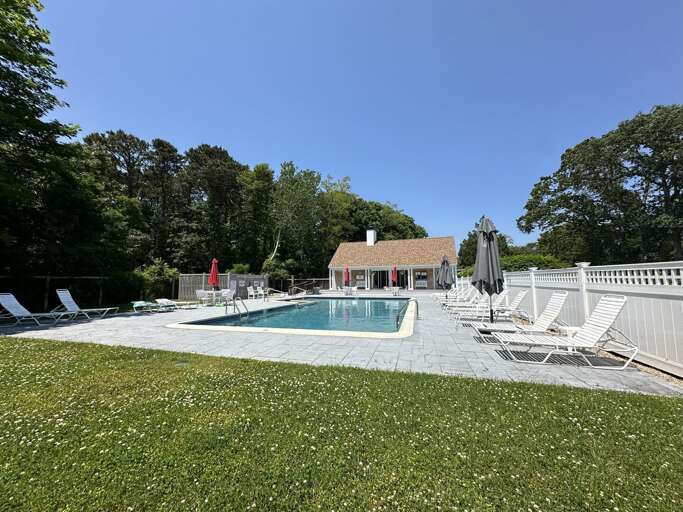Sunlit Poolside Paradise With Pristine Loungers And Lush Landscaping