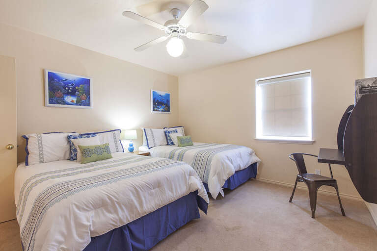 4th bedroom has two double size beds and features a writing table