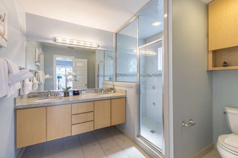 Large master bathroom with walk-in tiled shower.