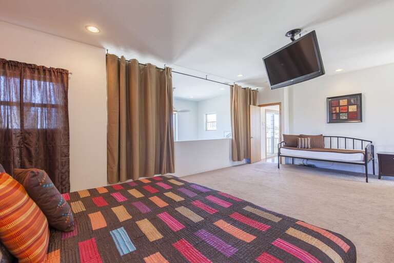 Grand Master Suite with a king bed, twin day bed, and mounted flat screen TV!