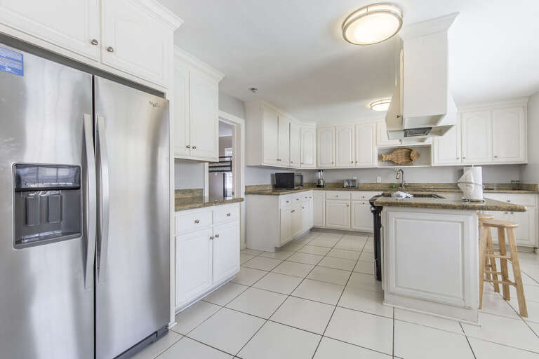 Large kitchen with additional bar seating and stainless steel appliances