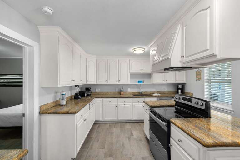 Large kitchen with additional bar seating and stainless steel appliances