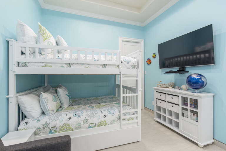Second floor bedroom with twin sofa sleeper, tin bunk beds, twin trundle bed, and crib