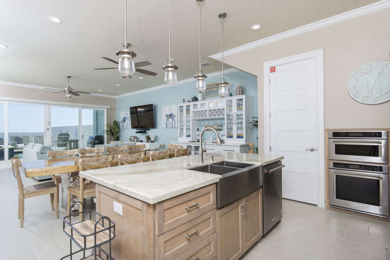 Fully stocked kitchen with stainless steel appliances including two microwaves, 2 ovens, and equipped with a gorgeous bar.