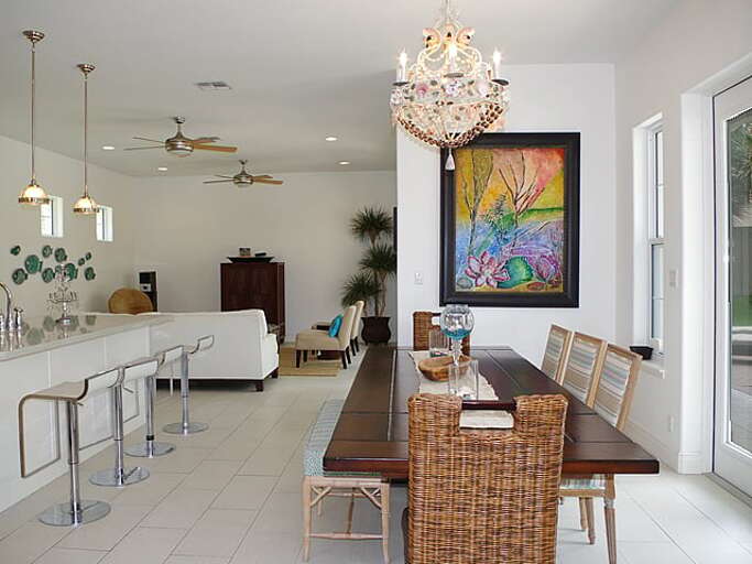 Open concept kitchen and dining areas are equipped with multiple french doors and windows overlooking the pool and providing lots of natural lighting