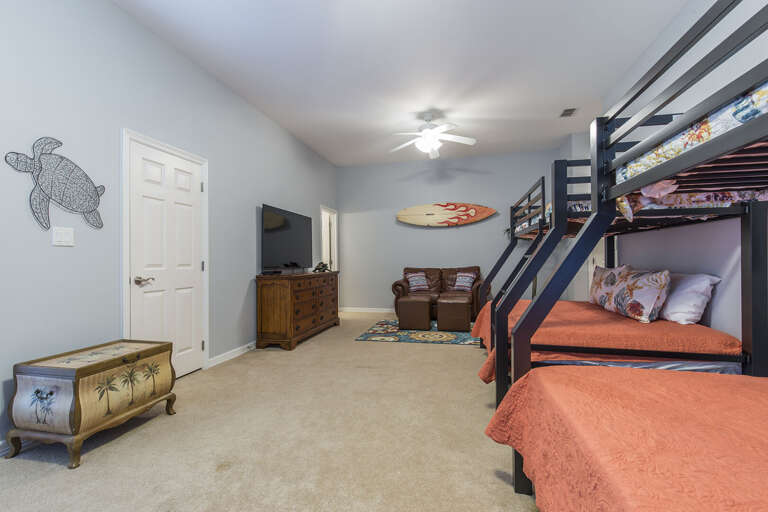 Second floor guest bedroom with 2 sets of bunk beds featuring a sitting area with a flat screen TV.