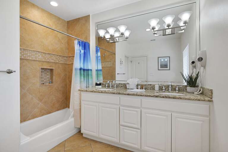 Guest bathroom with double vanity & bathtub/shower combination.