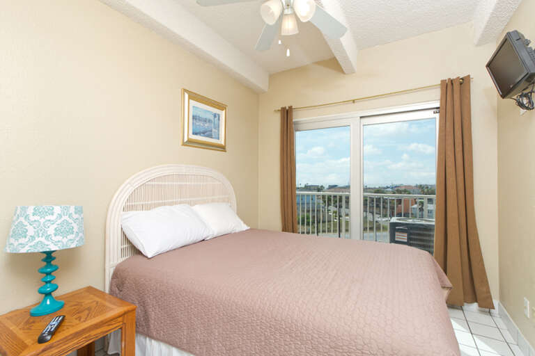 Master Bedroom with Queen size bed, flat screen TV and private balcony access.