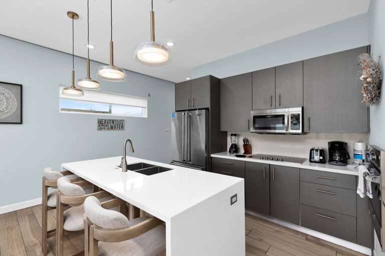 Sleek Kitchen Space With White Island And Gray Cabinets