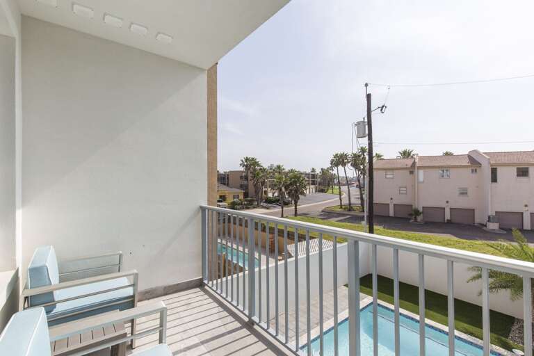 Second floor bedroom with a king bed  balcony over looking the pool.