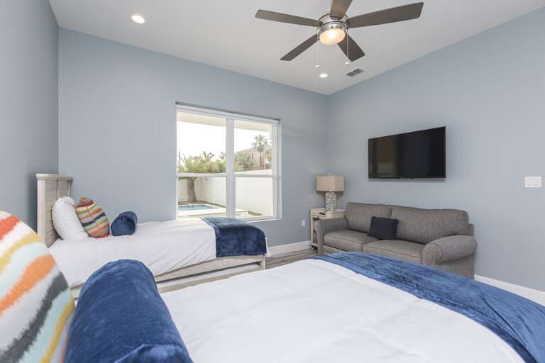 Guest bedroom with twin beds featuring trundle beds each and a 50" Smart TV (ground floor)