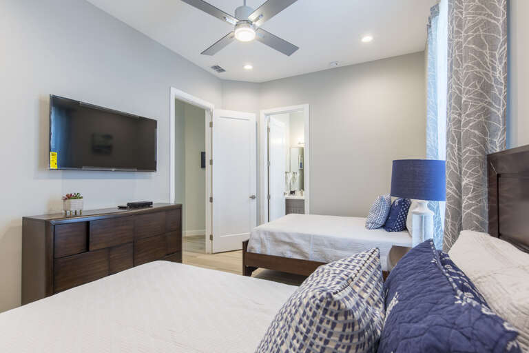 Second floor guest bedroom with full beds and flat screen TV