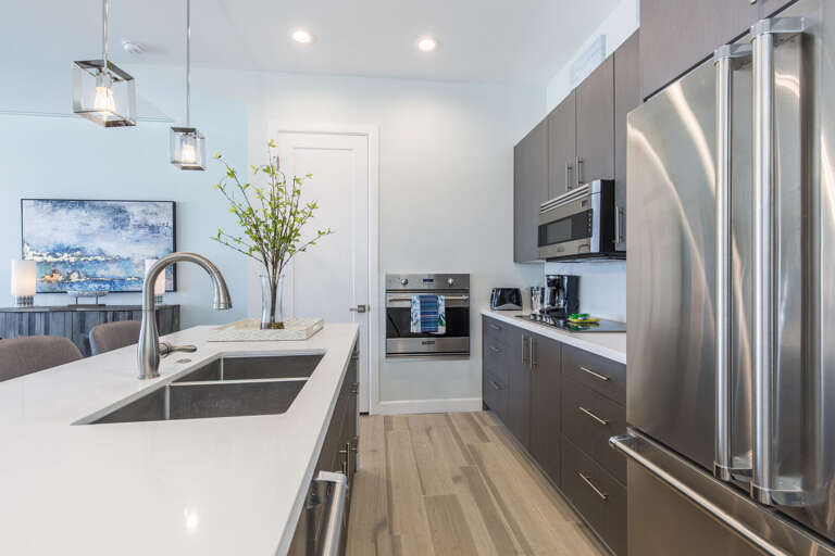 Fully stocked kitchen equipped with stainless steel appliances and a large center island.