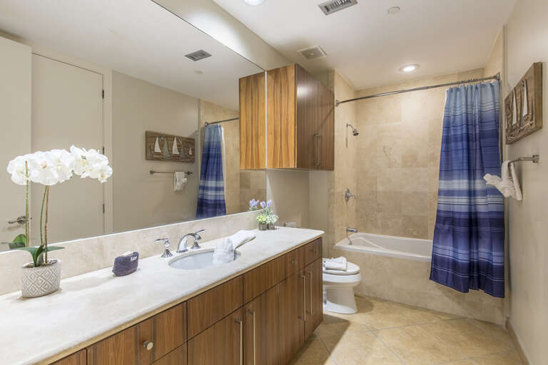 Private bathroom with a combination bathtub and shower. Large vanity mirror and plenty of counter space.