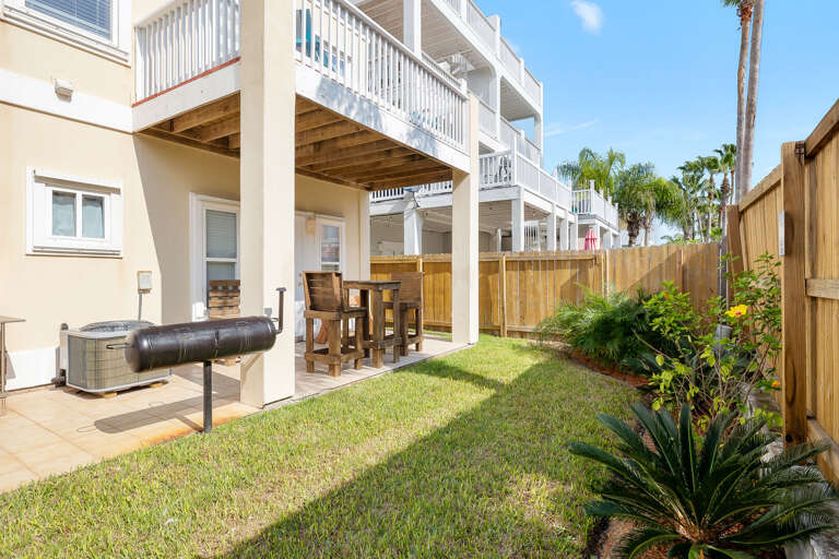 Backyard area with charcoal grill.