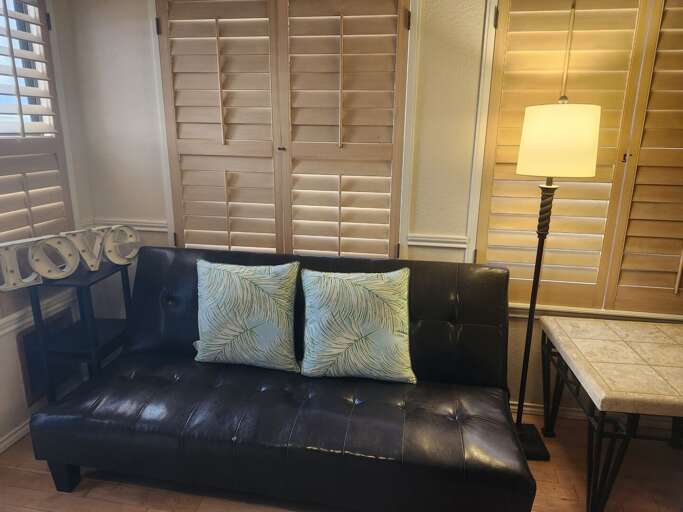 The living room features a cozy futon, offering extra seating or a comfortable sleeping option. The living room features a cozy futon, offering extra seating or a comfortable sleeping option.