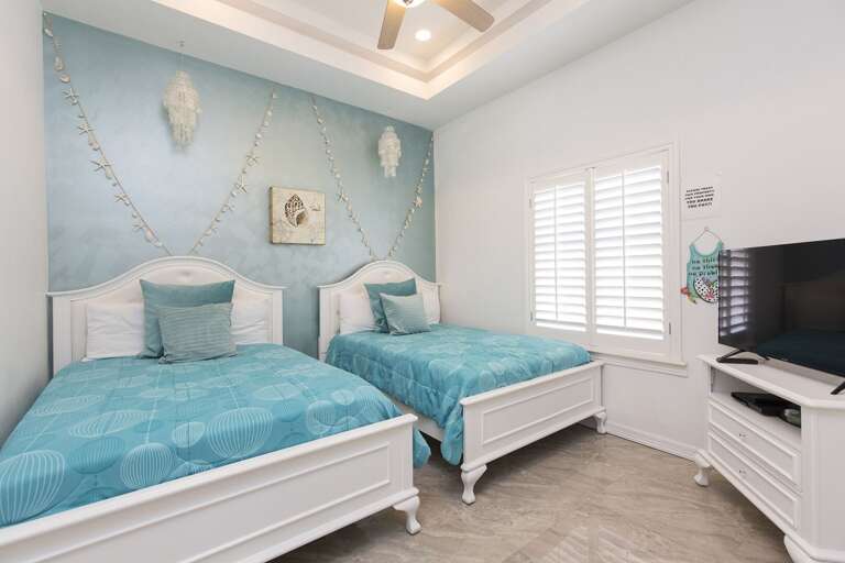 Guest room with two full beds and flat screen TV.