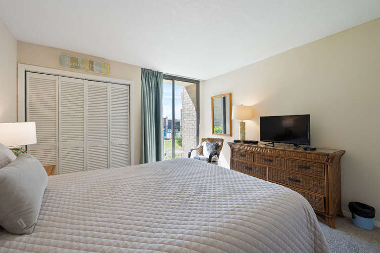 Guest bedroom with patio access leading to the pool area!