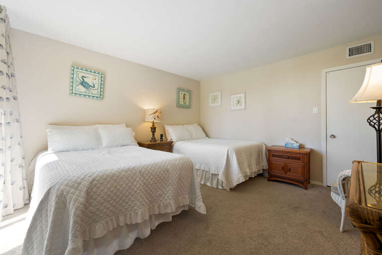 Guest room with two full beds and a flat screen TV.
