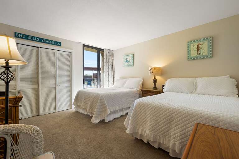 Guest room with two full beds and a flat screen TV.