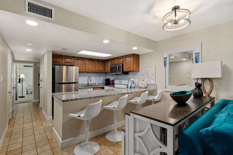Prepare meals with ease in the fully equipped kitchen featuring generous counter space and convenient breakfast bar seating.