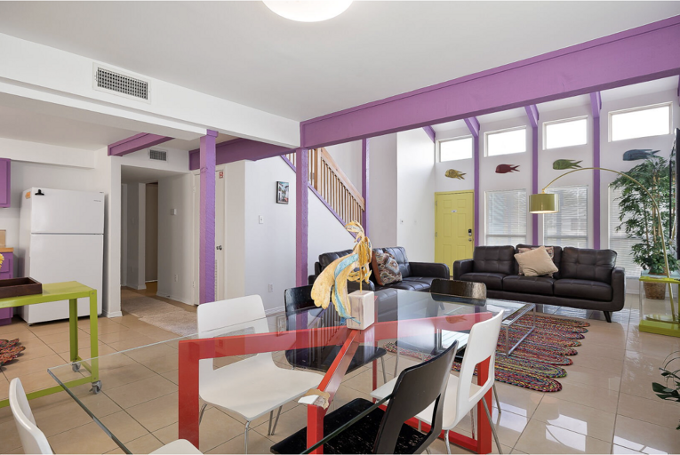 Bright, Spacious Living Space With Purple Partitions, Plentiful Plants, And A Playful Palette