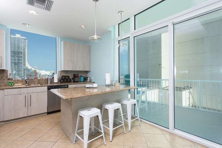 Kitchen with bar seating for 3 and stainless steal appliances. Sliding door provides access to the private balcony.