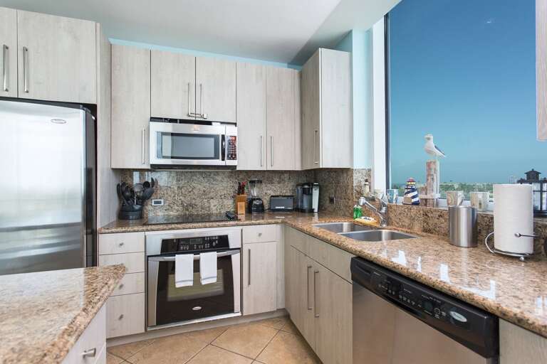 Kitchen with stainless steel appliances. A large kitchen window provides views of the bay!