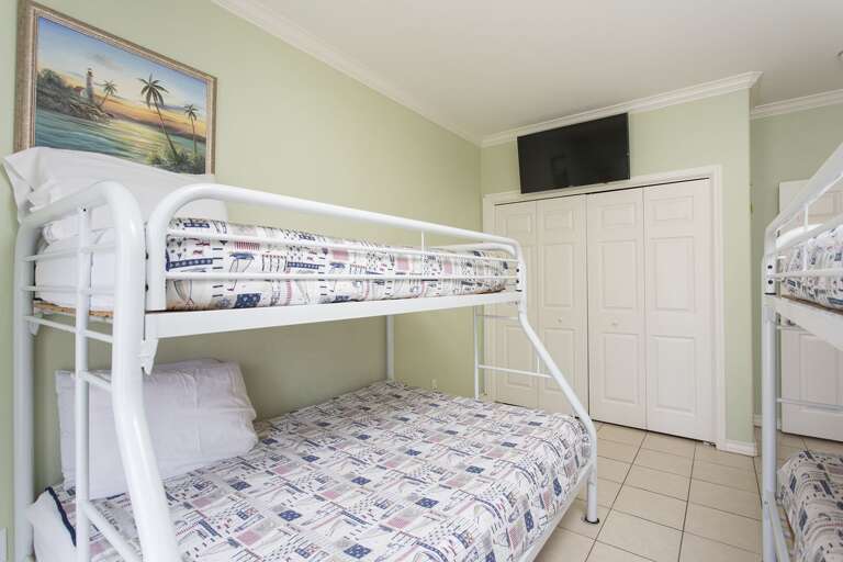 Guest bedroom with bunk beds (3 twin size and 1 full size bed).