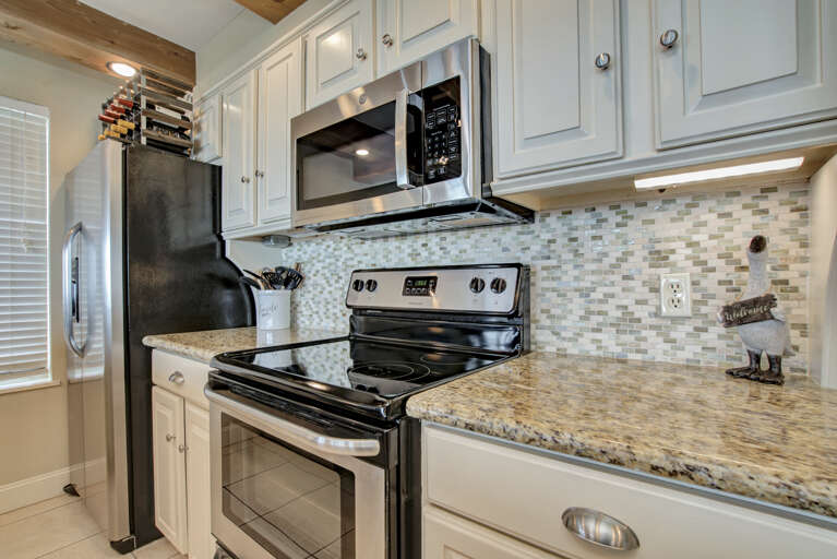 Microwave, conventional oven, and electric stove complemented by granite countertops. Microwave, conventional oven, and electric stove complemented by granite countertops.
