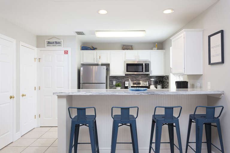 Kitchen area featuring bar seating. Kitchen area featuring bar seating.
