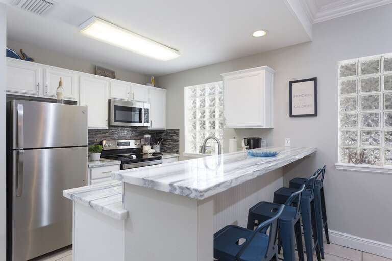 Kitchen area featuring bar seating. Kitchen area featuring bar seating.